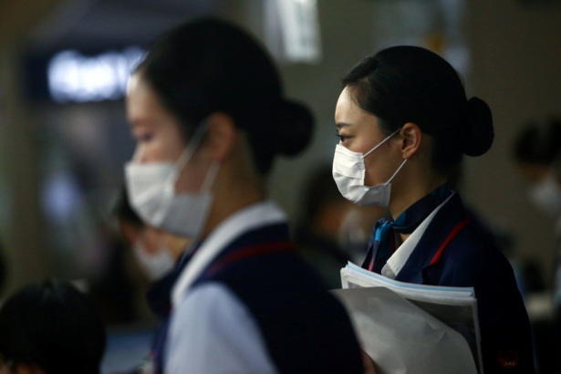 Employes, wearing protective masks following an outbreak of the coronavirus disease (COVID-19), are pictured at the Kansai International Airport in Osaka, Japan on March 14, 2020. (Edgard Garrido/Reuters)