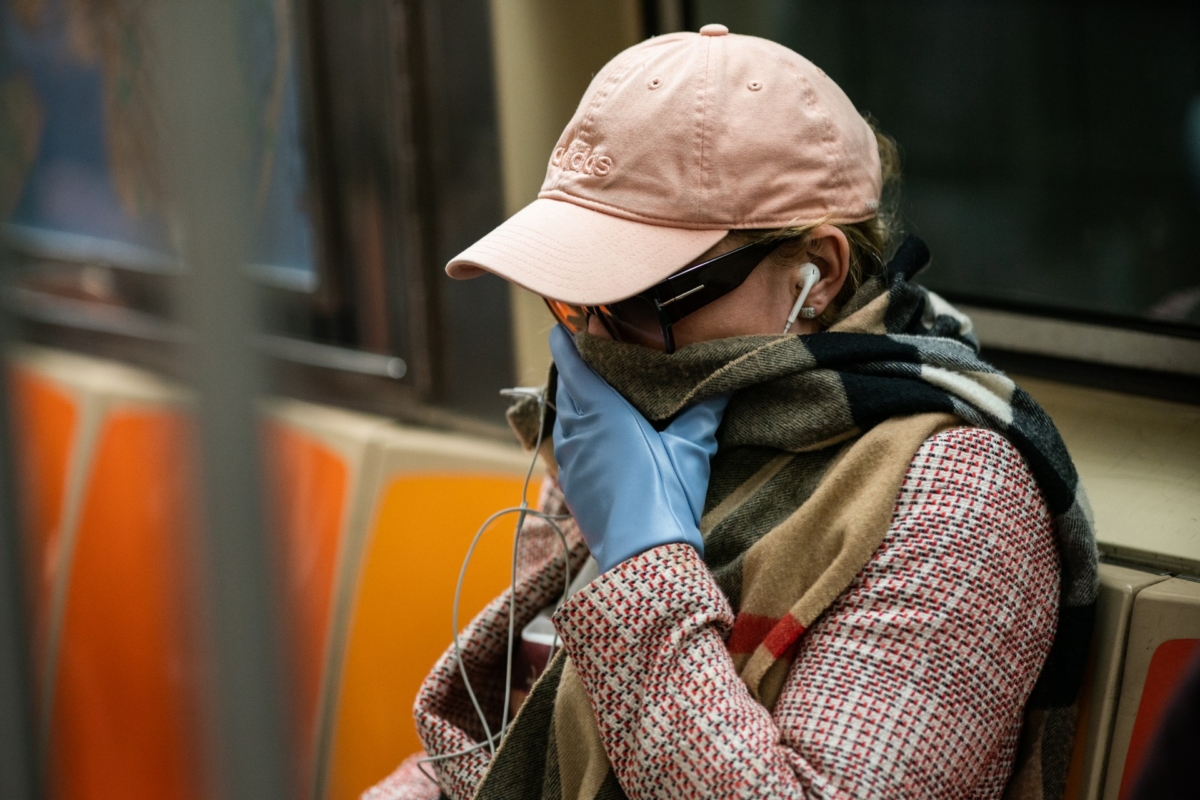 A woman wearing a protective mask sits in a subway car at Grand Central Terminal in New York City on March 12, 2020. (Jeenah Moon/Getty Images)