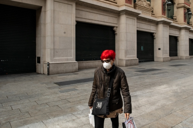 A woman wearing a protective mask walks past El Corte Ingles, a department store closed as measure against the coronavirus expansion in Barcelona, Spain, on March 14, 2020. (David Ramos/Getty Images)