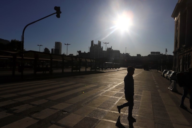 A man is silhouetted while crossing an empty street after Argentina's President Alberto Fernandez announced a mandatory quarantine, in Buenos Aires, Argentina March 20, 2020. (Reuters/Matias Baglietto)