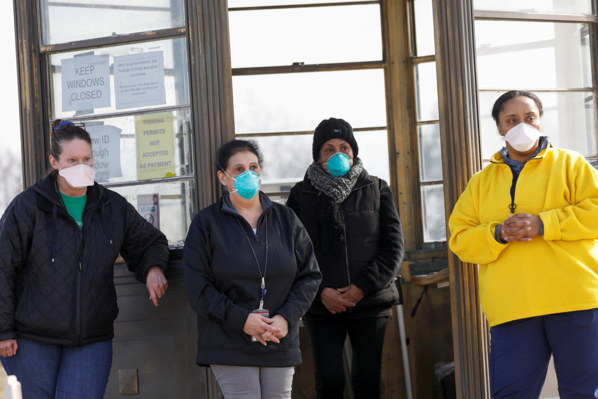Workers wait to assist people at the checkpoint of a testing facility for COVID-19 in Jones Beach on Long Island in New York on March 17, 2020. (Andrew Kelly/Reuters)