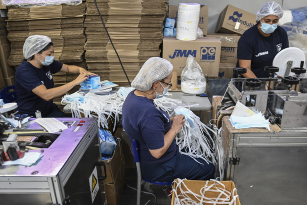 Women work in the assembly line of protective face masks at the JMM health supplies company, in Sabaneta, near Medellin, Colombia on March 9, 2020. (Joaquin Sarmiento/AFP via Getty Images)