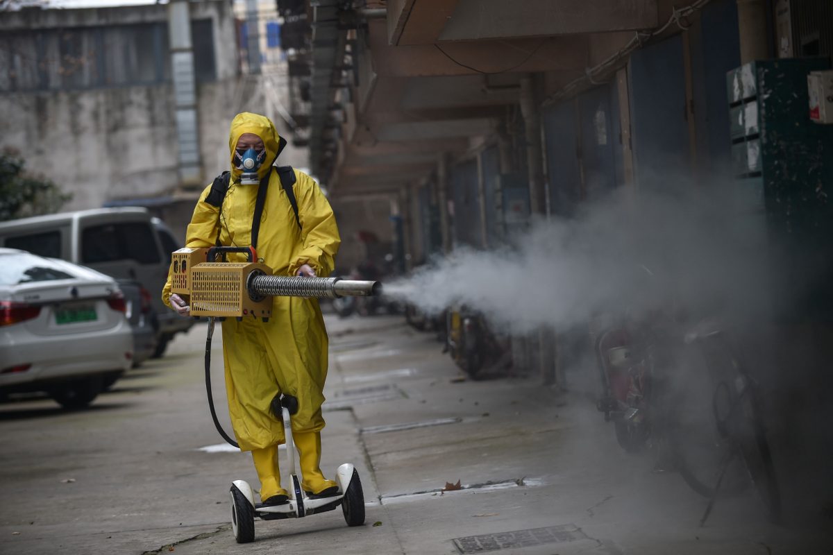 A medical staff member sprays disinfectant at a residential area in Wuhan in China's central Hubei province on March 11, 2020. (STR/AFP via Getty Images)