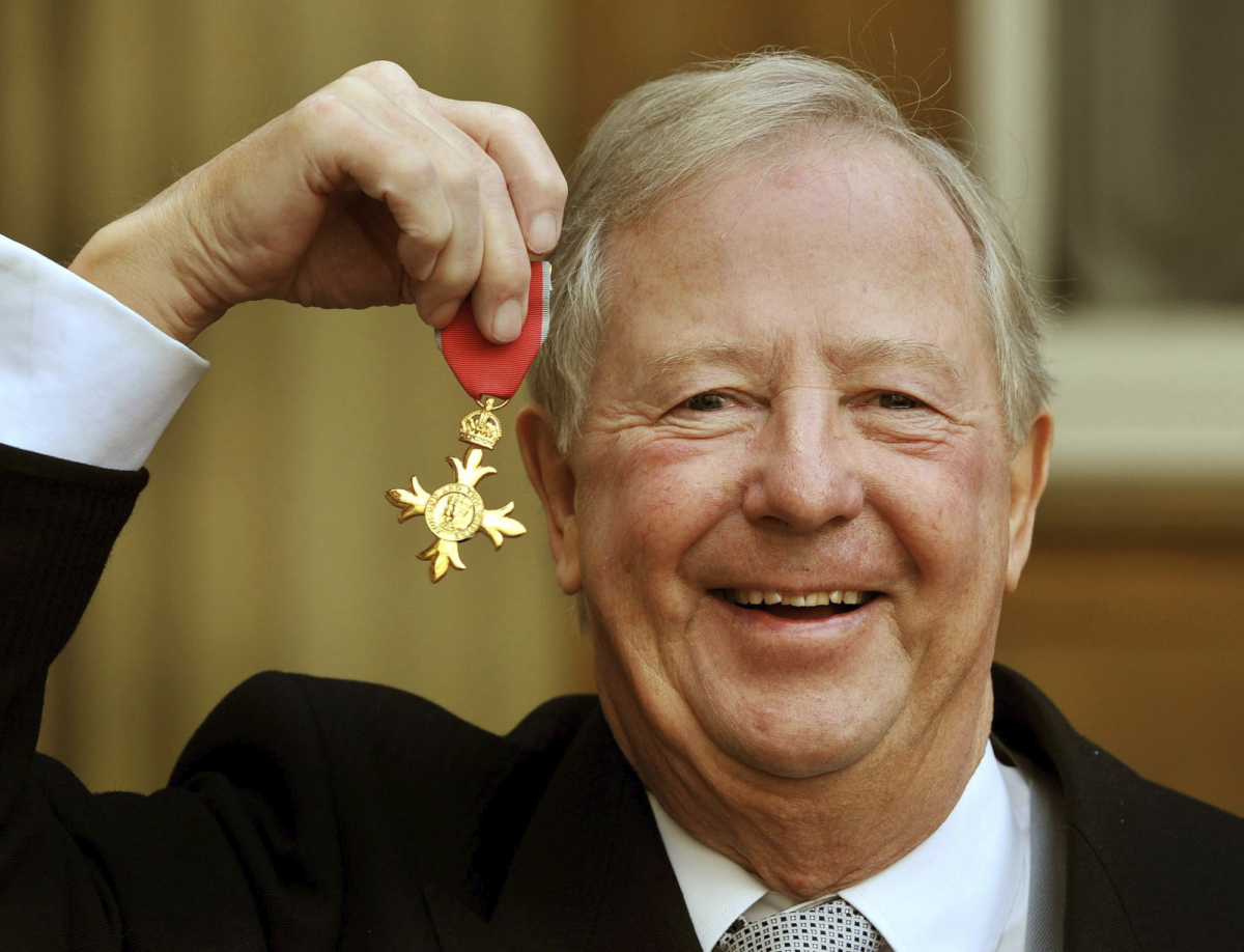 Tim Brooke-Taylor holds his OBE after being presented it by Queen Elizabeth, outside Buckingham Palace in London on Nov. 28, 2011. (John Stillwell/PA via AP)