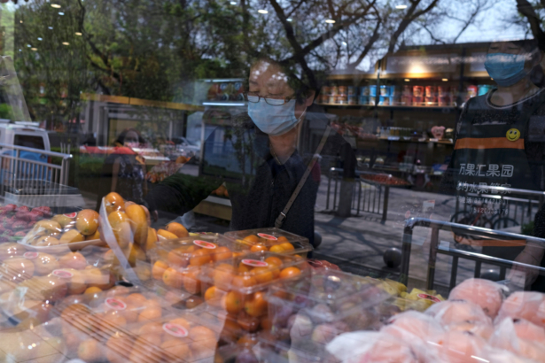 A woman wearing a face mask looks for products at a supermarket in Beijing, following an outbreak of the COVID-19 disease in China on April 17, 2020. (Carlos Garcia Rawlins/Reuters)