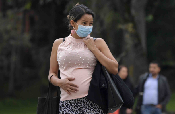 A pregnant woman wears a face mask as a preventive measure against the spread of the CCP virus as she waits for a bus in Bogota, Colombia, on March 16, 2020. (Raul Arboleda/AFP/Getty Images)