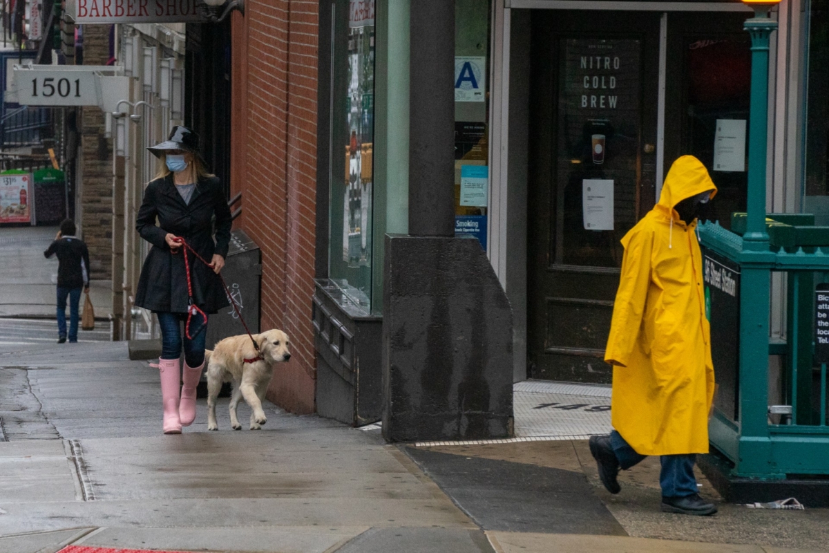 A person walks their dog while wearing a medical face mask in New York City, on April 13, 2020. (David Dee Delgado/Getty Images)