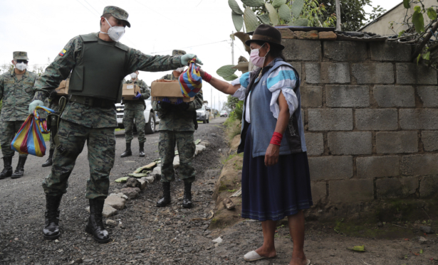 Soldiers deliver food to a woman who cannot leave her house because of the government's request that people don't leave their homes to prevent the coronavirus from spreading throughout the city in Zambiza, near Quito, Ecuador, on April 2, 2020. (Dolores Ochoa/AP Photo)