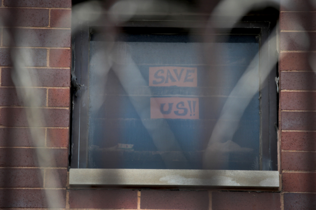 A sign pleading for help hangs in a window at the Cook County jail complex in Chicago, Ill., on April 9, 2020. (Scott Olson/Getty Images)