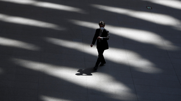 A man wearing a protective face mask, following an outbreak of the CCP virus, walks past inside an almost empty convention complex in Tokyo, Japan on April 6, 2020. (Issei Kato/Reuters)