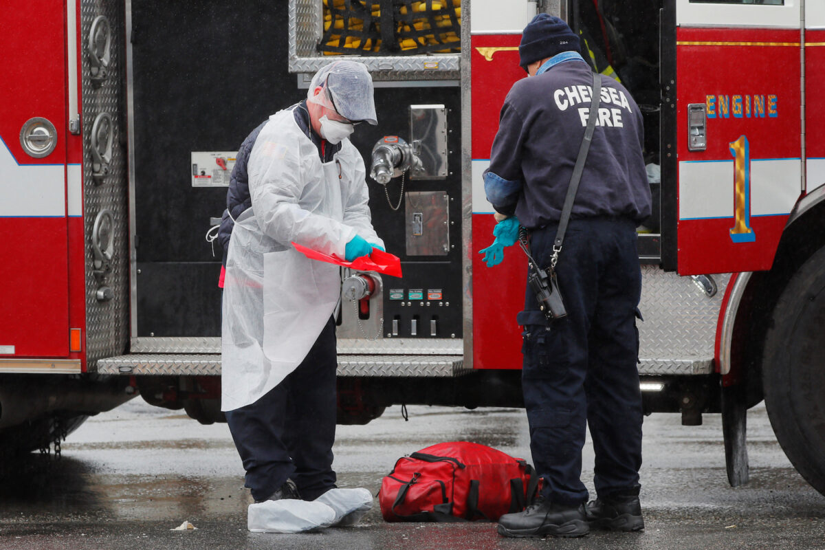 Firefighters remove personal protective equipment after responding to a medical call amid the COVID-19 outbreak in Chelsea, Massachusetts, on April 3, 2020. (Brian Snyder/Reuters)