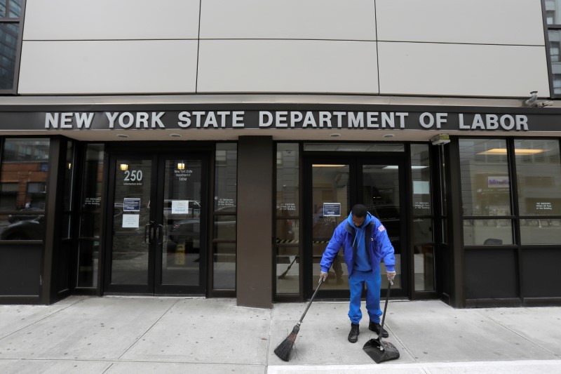 A person sweeps outside the New York State Department of Labor offices, which closed to the public due to the COVID-19 outbreak in Brooklyn, New York on March 20, 2020. (Andrew Kelly/Reuters)