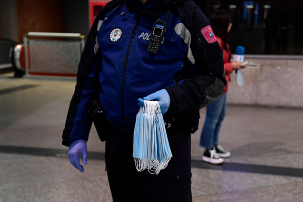 As some companies were set to resume operations at the end of a two-week halt of all non-essential activity amid a national lockdown to stop the spread of the CCP virus, a Spanish police officer distributes masks at the Atocha Station in Madrid on April 13, 2020. (Javier Soriano/AFP via Getty Images)