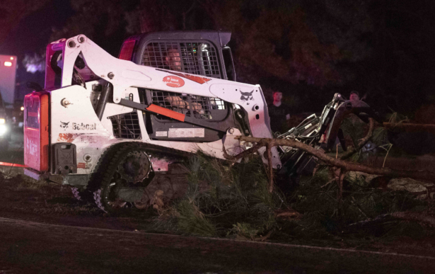 A tree is removed from a road after an apparent tornado touched down in Onalaska, Texas, on April 22, 2020. (Jason Fochtman/Houston Chronicle via AP)