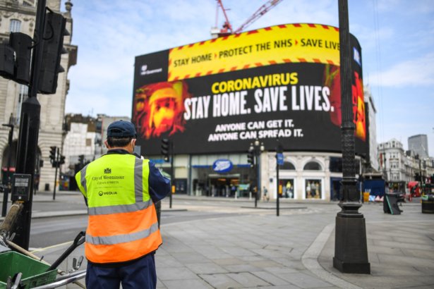 A street cleaner is seen in front of CCP virus messaging on Piccadilly Circus in London on April 8, 2020. (Peter Summers/Getty Images)