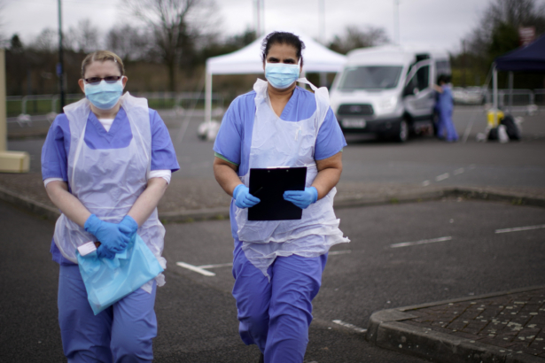 NHS nurses wait for the next patient at a drive-through CCP virus testing site in a car park in Wolverhampton, England, on March 12, 2020. (Christopher Furlong/Getty Images)