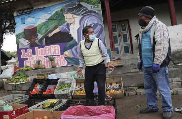 A vendor wearing a mask to protect himself from the spread of the CCP virus offers fruits and vegetables at an intersection in Quito, Ecuador, on March 31, 2020. (Dolores Ochoa/AP Photo)