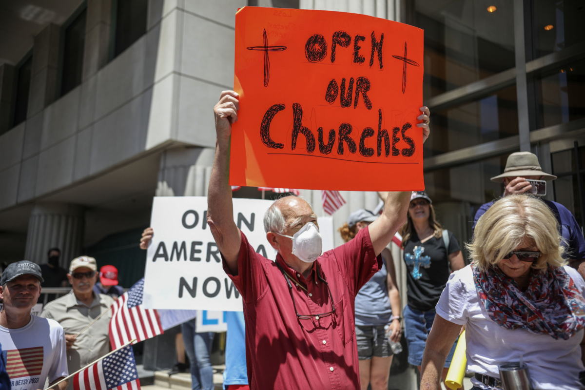 Demonstrators holding signs demanding their church to reopen, protest during a rally to re-open California and against Stay-At-Home directives in San Diego, Calif., on May 1, 2020. (Sandy Huffaker/AFP via Getty Images)