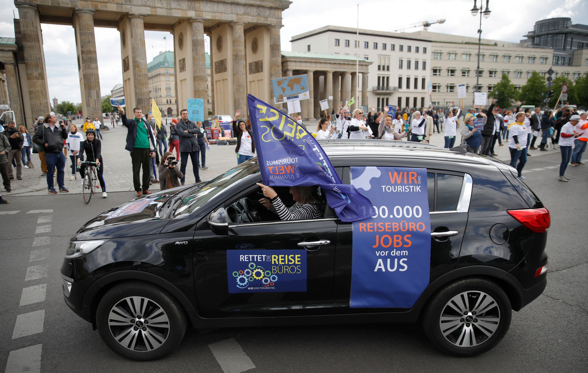 Travel agency workers demonstrate close to Berlin's landmark the Brandenburg Gate in order to point to the economic plight of the touristic sector, claiming for rescue packages to save jobs amid the CCP virus / COVID-19 pandemic, Berlin, Germany, on May 13, 2020. (Odd Andersen/ AFP via Getty Images)