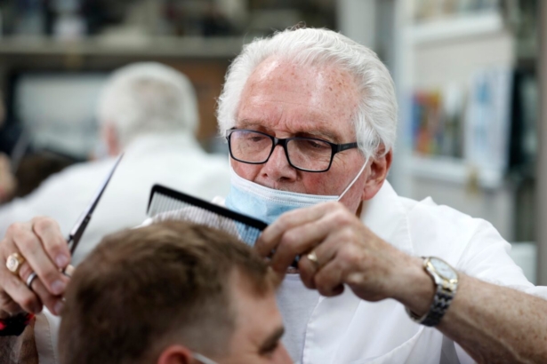 Barber Karl Manke cuts a client's hair at his barber shop in Owosso, Mich., on May 12, 2020. (Jeff Kowalsky/AFP/Getty Images)