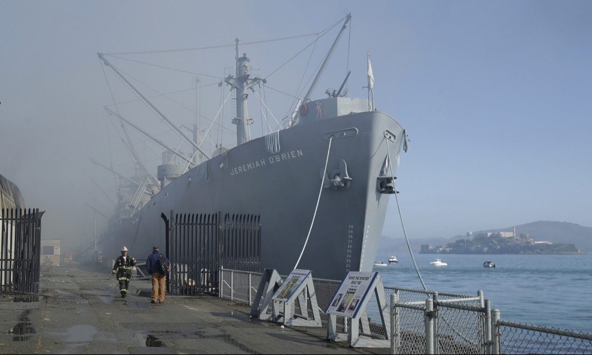 Fire officials work in front of a sign for Musee Mecanique after a fire broke out before dawn at Fisherman's Wharf in San Francisco, on May 23, 2020. (Jeff Chiu/AP photo)
