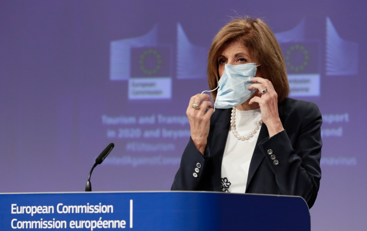 European Commissioner for Health Stella Kyriakides removes a mouth mask after addressing a media conference regarding tourism at EU headquarters in Brussels, on May 13, 2020. (Olivier Hoslet/ Pool Photo via AP)