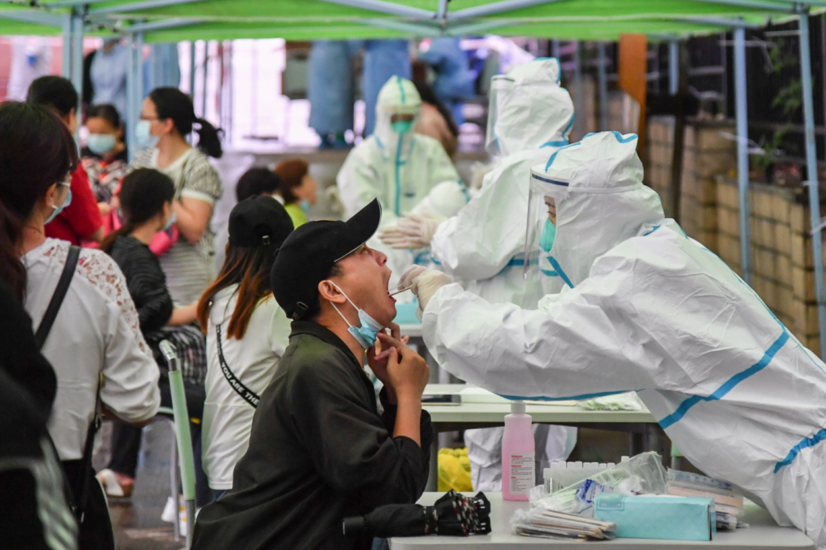 A medical worker takes a swab sample from a resident to be tested for the coronavirus in Wuhan, China, on May 14, 2020. (STR/AFP via Getty Images)