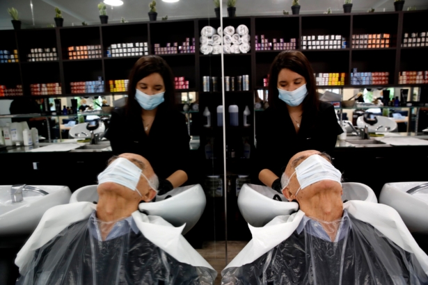 A man gets a hair cut at a hairdressing salon in Sevres, outside Paris, France, on May 11, 2020. (Christophe Ena/AP Photo)
