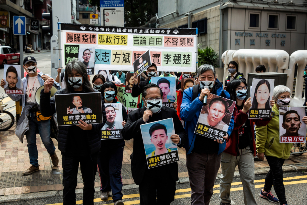 Pro-democracy protesters from HK Alliance hold placards of detained rights activists as they march towards the Chinese liaison office, in protest against Beijings detention of prominent anti-corruption activist Xu Zhiyong, in Hong Kong, China, on Feb. 19, 2020. (Isaac Lawrence/ AFP via Getty Images)