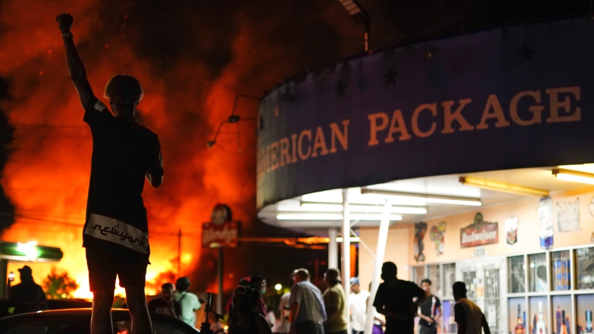 A protester watches as a Wendy’s burns following a rally against racial inequality and the police shooting death of Rayshard Brooks, in Atlanta, Ga., on June 13, 2020. (Elijah Nouvelage/Reuters)
