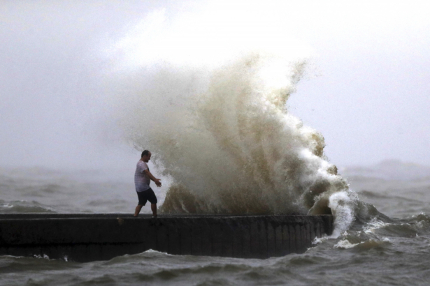 A wave crashes as a man stands on a jetty near Orleans Harbor in Lake Pontchartrain in New Orleans, as Tropical Storm Cristobal approaches the Louisiana Coast, on June 7, 2020. (Gerald Herbert/AP Photo)
