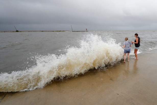 Erin Shaw (L) and Brittany Schanzbach stand near crashing waves near the seawall of Lake Pontchartrain from a storm surge in New Orleans, as Tropical Storm Cristobal approaches the Louisiana Coast, New Orleans, La., on June 7, 2020. (Gerald Herbert/AP Photo)