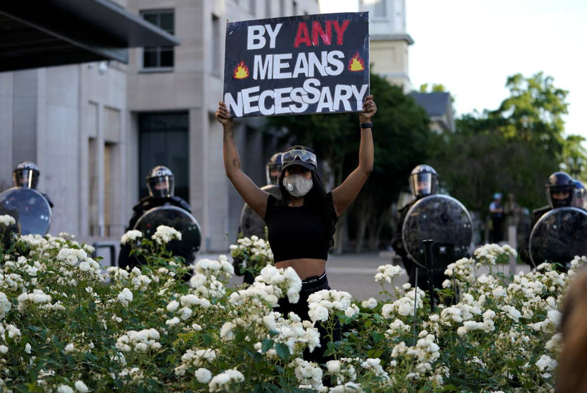 A demonstrator holds up a sign in front of a police line during protest in downtown Washington on June 1, 2020. (Drew Angerer/Getty Images)