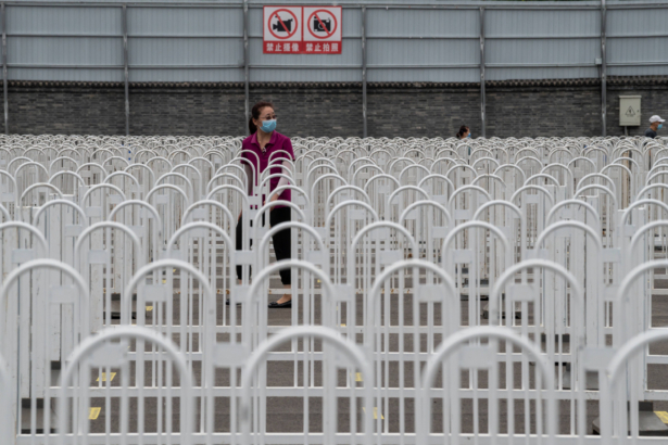 People wearing face masks gather at an outdoor area during a mass testing for the CCP virus at the Jinrong Street testing site in Beijing, China, on June 24, 2020. (Nicolas Asfouri/AFP via Getty Images)