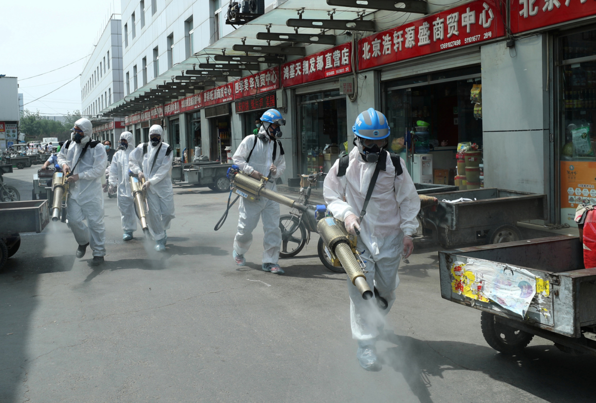 Volunteers from Blue Sky Rescue team in protective suits disinfect the Yuegezhuang wholesale market, following new cases of coronavirus disease (COVID-19) infections in Beijing, China on June 16, 2020. (China Daily via Reuters)