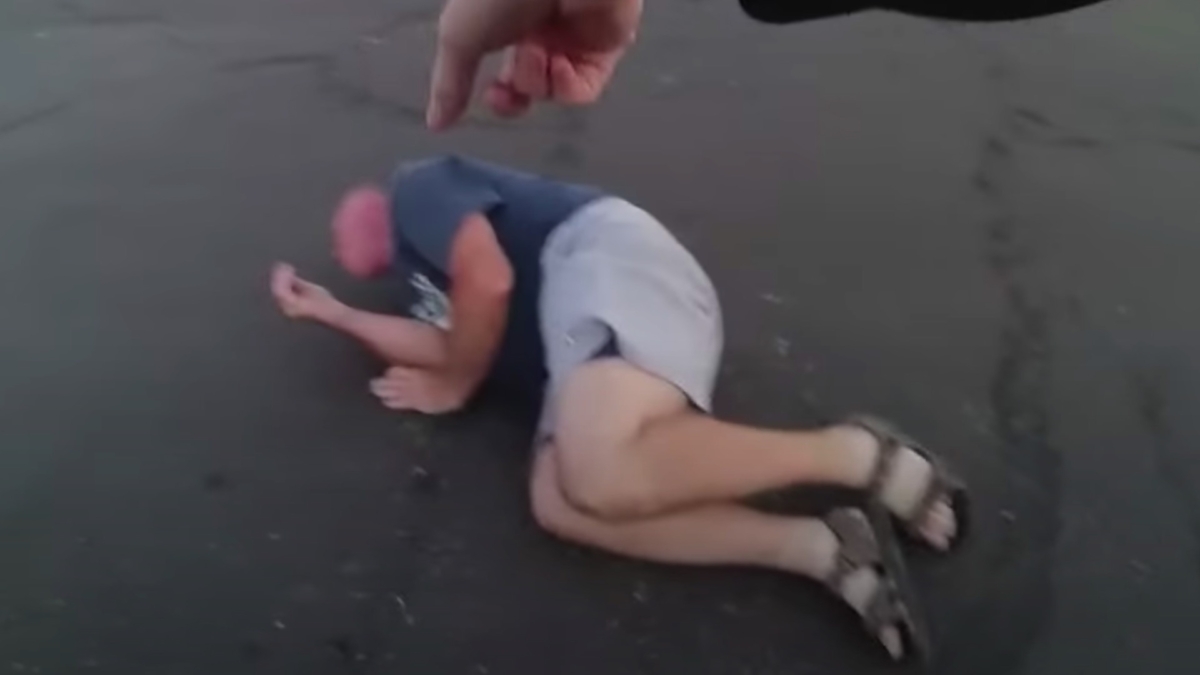 Jon David Brouseau, 55, rolling on the concrete of a parking lot after an officer-involved shooting in Phoenix, Arizona on June 14, 2020. (Phoenix Police Department)
