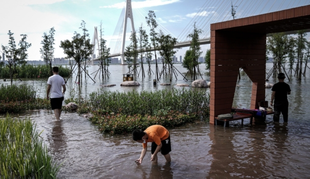 Residents wear masks while walking through Jiangtan park that flooded because of heavy rains along the Yangtze River in Wuhan, China on July 8, 2020. (Getty Images)