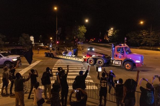 A group of people in support of the removal of the Christopher Columbus statue cheer as the it is driven away from Grant Park in Chicago in the pre-dawn hours of July 24, 2020. (Tyler LaRiviere/Sun-Times/Chicago Sun-Times via AP)