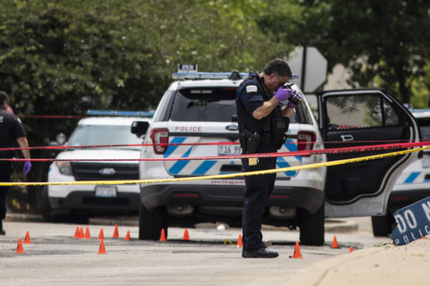 Chicago Police investigate at the 25th District station on the northwest side, in Chicago, after several officers were shot outside the station, Chicago, on July 30, 2020. (Ashlee Rezin Garcia/Chicago Sun-Times via AP)
