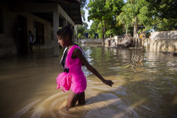 A girl wades towards her flooded home the day after the passing of Tropical Storm Laura in Port-au-Prince, Haiti, on Aug. 24, 2020. (Dieu Nalio Chery via AP Photo)