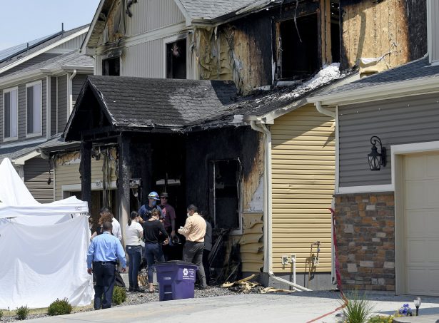 Investigators stand outside a house where five people were found dead after a fire in suburban Denver on Aug. 5, 2020. (Thomas Peipert/AP Photo)