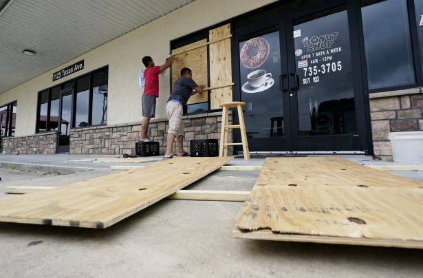 Daoith Porm, left, and Bunsant Khov, right, board their business with Hurricane Laura just hours away on Aug. 26, 2020, in Bridge City, Texas. (Eric Gay/AP Photo)