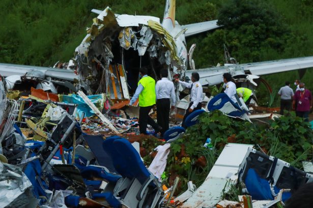 Officials inspect the wreckage of an Air India Express jet at Calicut International Airport in Karipur, Kerala, on Aug. 8, 2020. (Arunchandra Bose / AFP via Getty Images)
