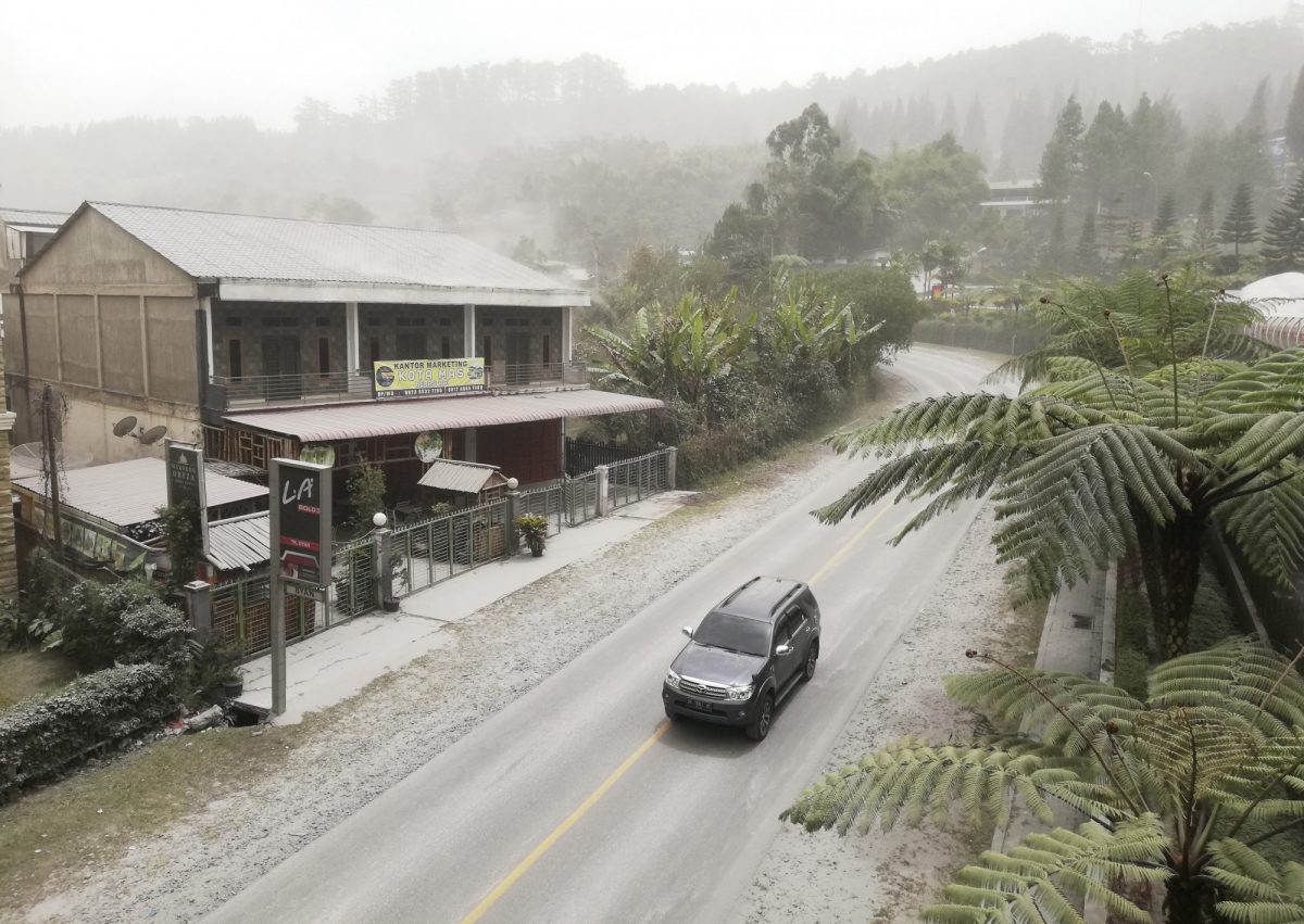 A car drives on a road covered with volcanic ash from the eruption of Mount Sinabung, in Karo, North Sumatra, Indonesia, on Aug. 10, 2020. (Sugeng Nuryono/AP Photo)