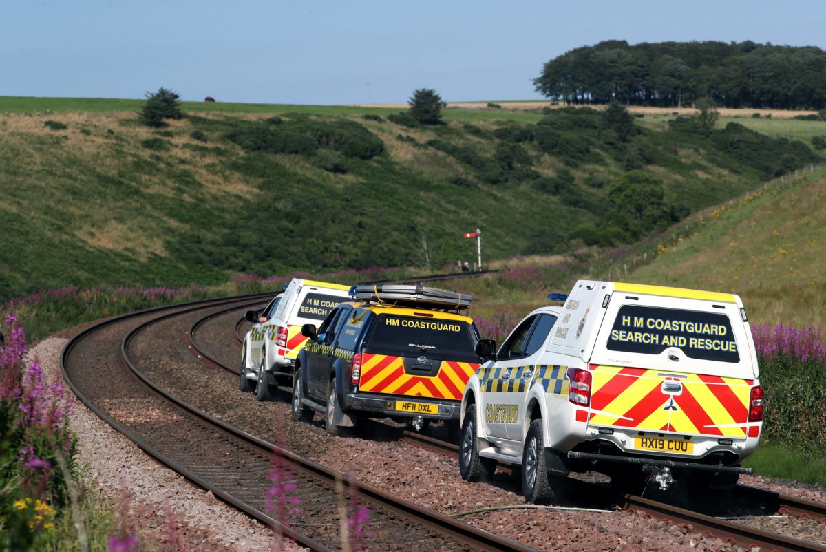 Emergency service vehicles ride along the tracks near the scene of a derailed passenger train, near Carmont, Stonehaven, Scotland, Britain, on Aug. 12, 2020. (Russell Cheyne/Reuters)