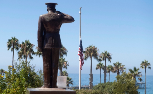Former San Clemente Mayor Wayne Eggleston lowers the U.S. flag to half-staff at Park Semper Fi in San Clemente, Calif., on July 31, 2020. (Paul Bersebach/The Orange County Register via AP)