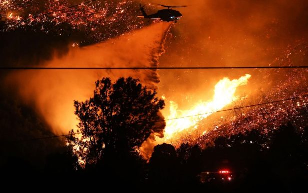 A firefighting helicopter performs a water drop over the Lake Fire in Lake Hughes, Calif., on Aug. 12, 2020. (Mario Tama/Getty Images)