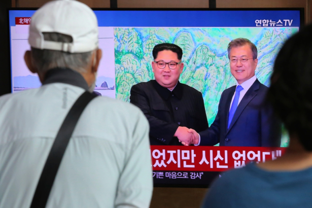 People watch a TV showing a file image of North Korean leader Kim Jong Un (L) and South Korean President Moon Jae-in during a news program at the Seoul Railway Station in Seoul, South Korea, on Sept. 25, 2020. (Ahn Young-joon/AP Photo)