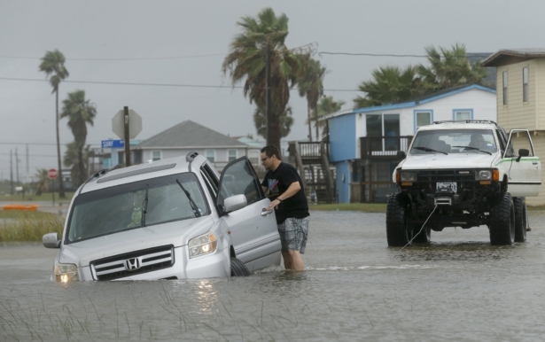 Jeff Williams gets back in his vehicle to try to get it out of the flooded road on Sept. 21, 2020, in Surfside, Texas. (Godofredo A. Vásquez/Houston Chronicle via AP)