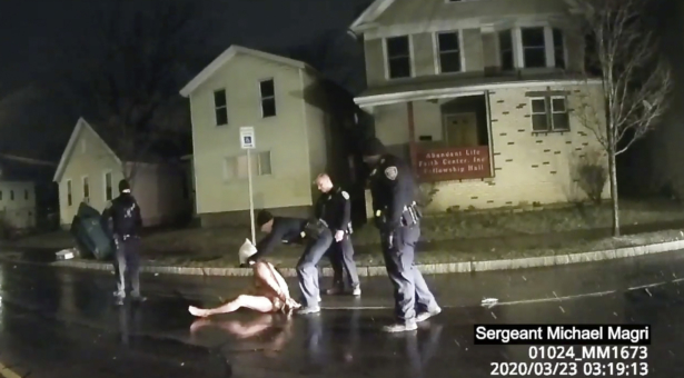 In this still image from police body camera video, a Rochester police officer puts a hood, known as a "spit sock," over the head of Daniel Prude in Rochester, N.Y., on March 23, 2020. (Rochester Police Department, via AP News)